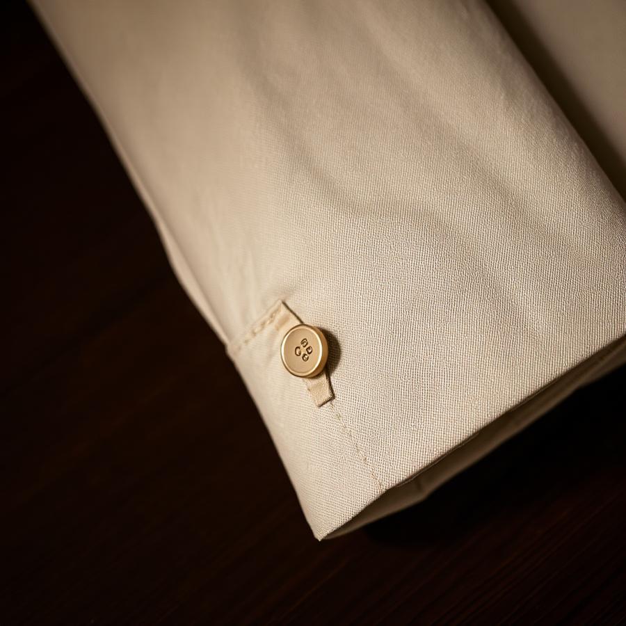 Cream linen jacket sleeve with hand-stitched buttonhole